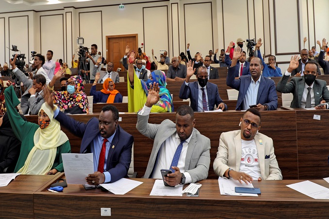 somalia legislators vote by rising their hands to cancel a divisive two year presidential term extension, inside the lower house of parliament in mogadishu