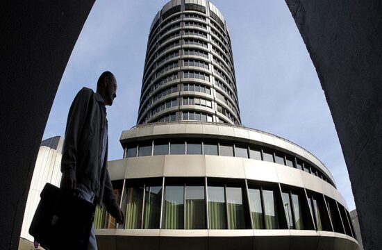 a man walks past the headquarters of the bank for international settlements (bis) in basel