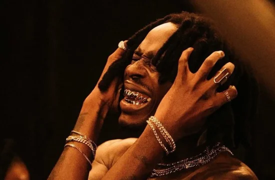 Afrobeats performer entertaining a crowd during a live African music event.